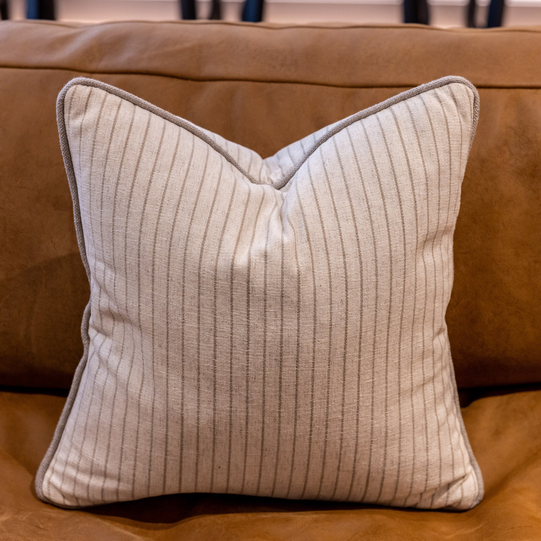Luxury striped linen mix fabric cushion with a taupe coloured piping. Colour is cream with a taupe colored stripe 12mm apart. A plump feather inner cushion is included. Our made to order cushions are plump and cosy. Dimensions: 500 x 500 mm Made to order in approx 3 weeks